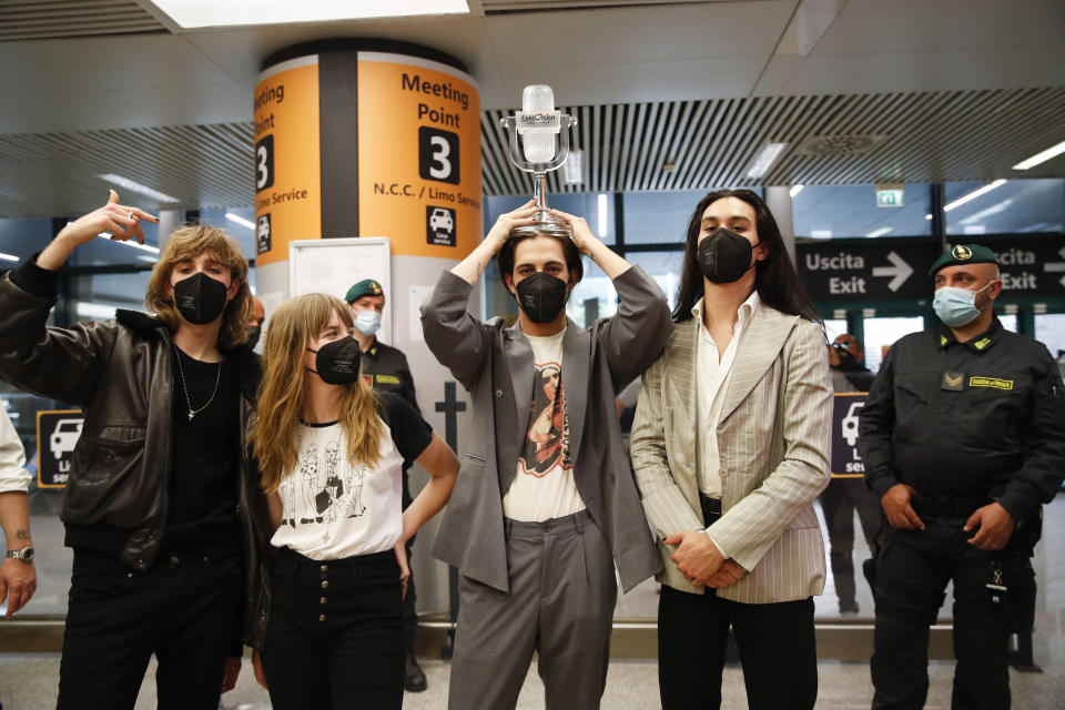 From left, Thomas Raggi, Victoria De Angelis, Damiano David, and Ethan Torchio, of Italian band Maneskin, pose for photographers upon their arrival at Rome's Fiumicino airport, Sunday, May 23, 2021. The glam rock band who got their start busking on Rome's main shopping drag won the Eurovision Song Contest Saturday and brought next year's competition back to the place where Europe's song contests began. (AP Photo/Alessandra Tarantino)