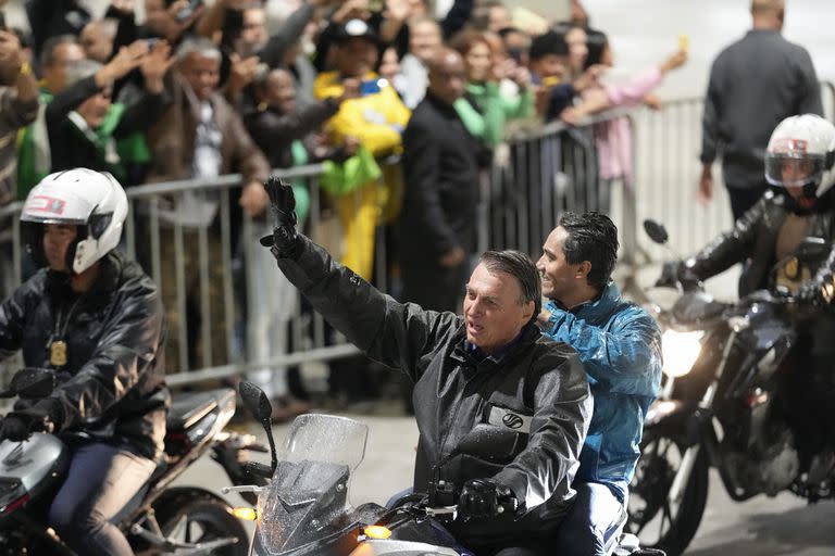 El presidente brasileño Jair Bolsonaro saluda a sus simpatizantes durante un evento de su campaña por la reelección, el miércoles 28 de septiembre de 2022, en Santos, Brasil