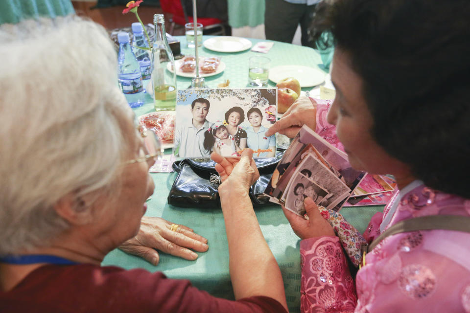 South Korean Chun Hye-ock, 90, left, and her North Korean niece Kim Yun Kyung, 56, watch their family photos during the Separated Family Reunion Meeting at the Diamond Mountain resort in North Korea, Monday, Aug. 20, 2018. Dozens of elderly South Koreans crossed the heavily fortified border into North Korea on Monday for heart-wrenching meetings with relatives most haven't seen since they were separated by the turmoil of the Korean War. (Korea Pool Photo via AP)