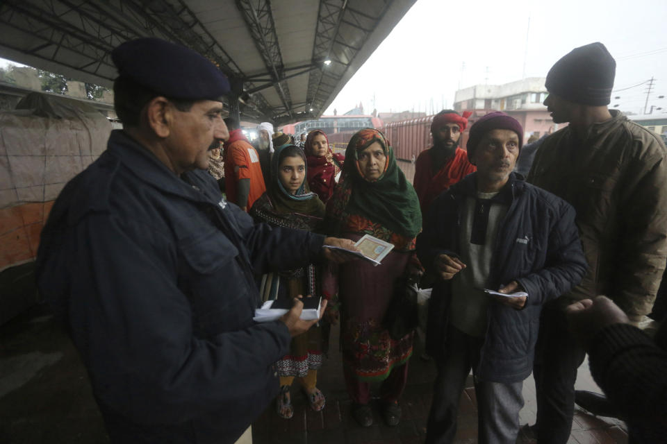 A Pakistani police officer checks documents of passengers travel to India via Samjhota Express at Lahore railway station in Pakistan, Thursday, Feb. 21, 2019. Indian authorities suspended a bus service this week without explanation. The development comes amid escalated tensions between Pakistan and India in the wake of last week's deadly suicide bombing in Kashmir against Indian paramilitary troops. (AP Photo/K.M. Chaudary)