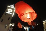 Revellers launch a paper lantern into the sky as they celebrate New Year's Day in the centre of Rosa Khutor, a venue for the Sochi 2014 winter Olympics, some 40 kilometres (25 miles) east from Sochi December 31, 2013. REUTERS/Maxim Shemetov (RUSSIA - Tags: SPORT OLYMPICS SOCIETY) )