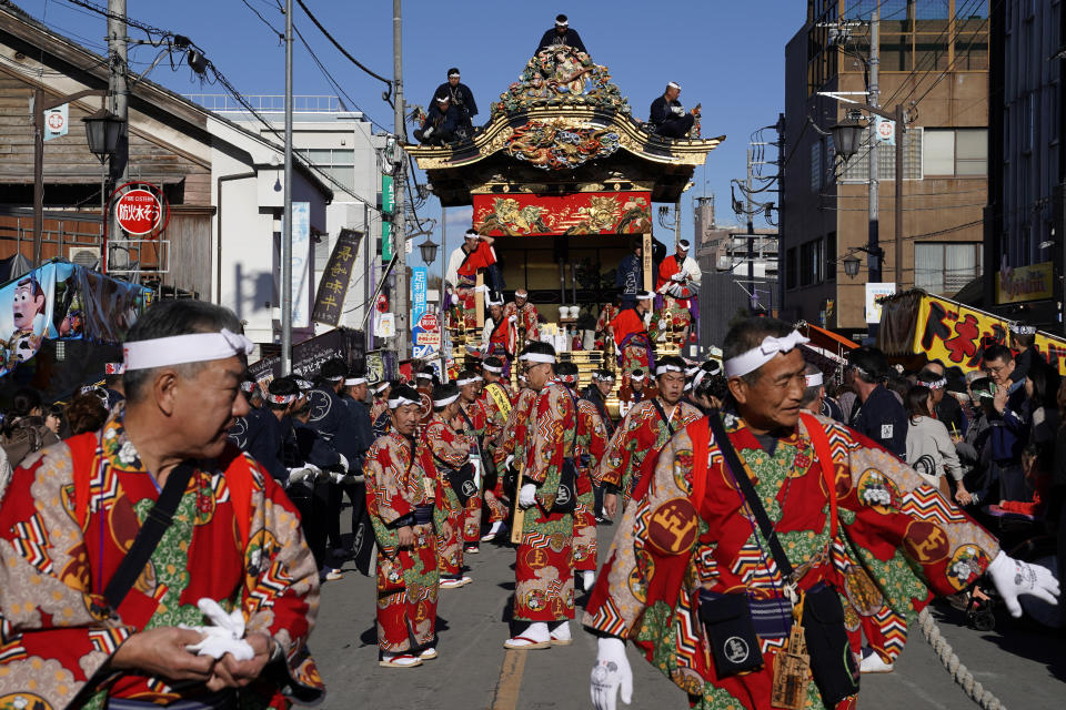 In this Tuesday, Dec. 3, 2019, photo, participants clad in kimonos prepare to pull a float before it goes to the town central square at the Chichibu Night Festival in Chichibu, north of Tokyo, Japan. Moving six towering floats up a hill and into the town center is the culminating moment of a Shinto festival that has evolved from a harvest thanksgiving into a once-a-year meeting between two local gods. (AP Photo/Toru Hanai)