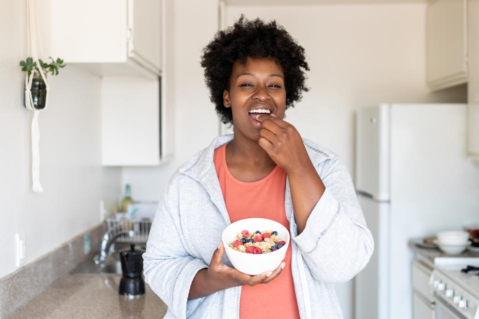 woman having oat granola with blueberries for breakfast