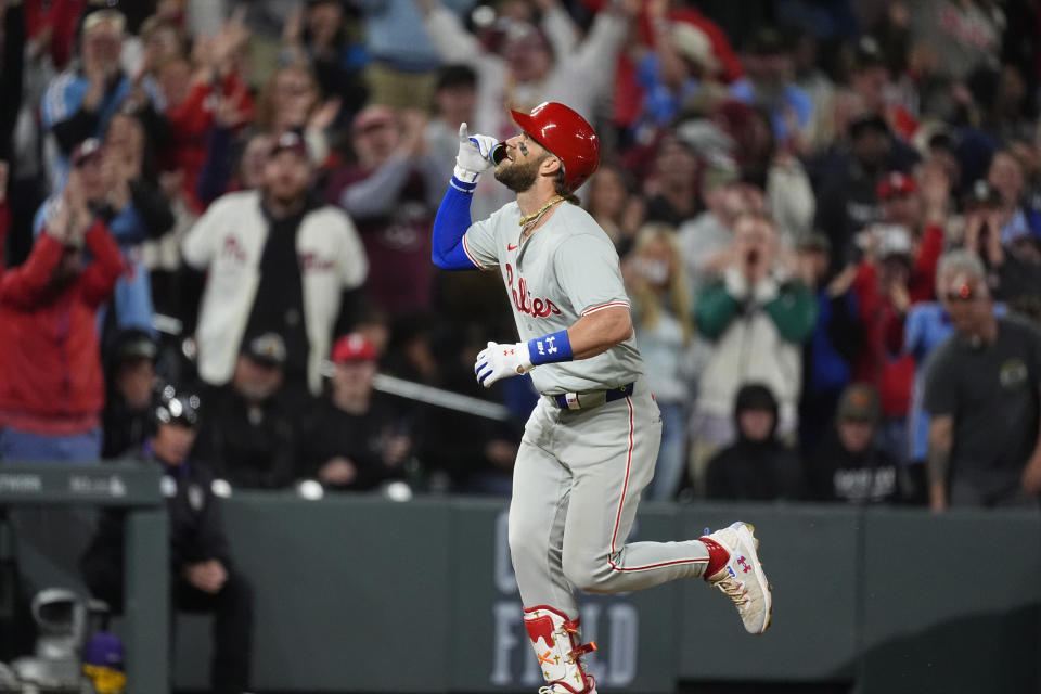 Philadelphia Philliesd' Bryce Harper gestures as he runs the bases after hitting a three-run home run off Colorado Rockies relief pitcher John Curtiss during the ninth inning of a baseball game Saturday, May 25, 2024, in Denver. (AP Photo/David Zalubowski)