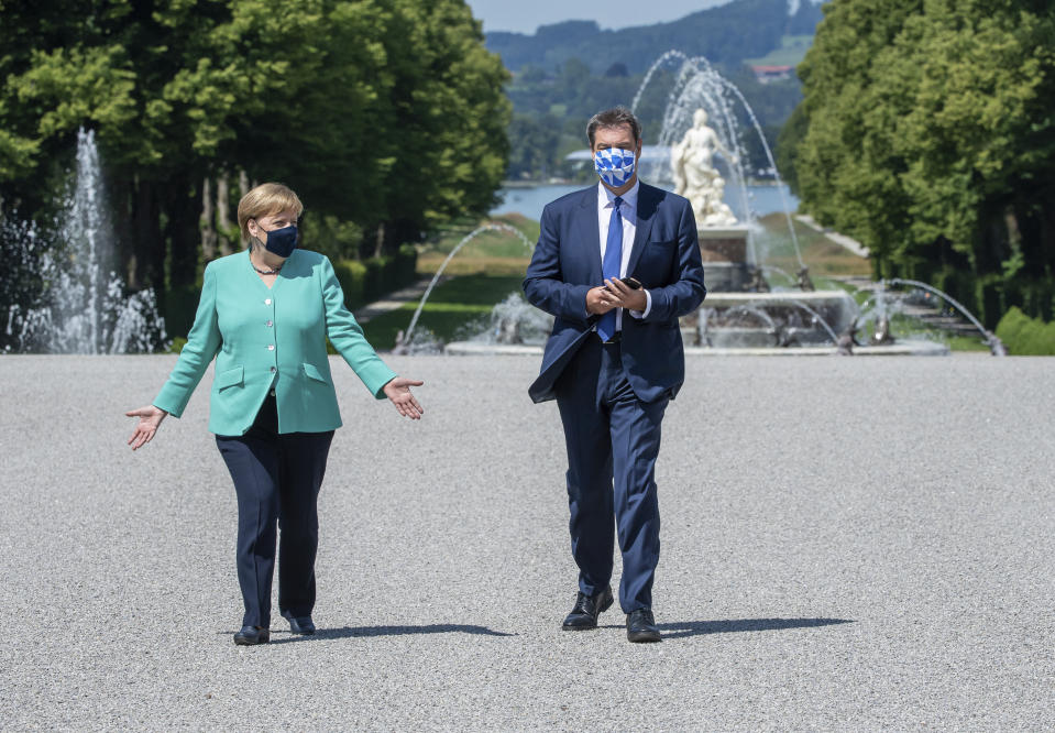 German Chancellor Angela, left, and Markus Soeder, right, Governour of the German state of Bavaria, arrive at the Herrechiemsee island, Germany, Tuesday, July 14, 2020. German Chancellor Angela Merkel attends a meeting of the Bavarian state cabinet at the 'Herrenchiemsee' palace. (Peter Kneffel/DPA via AP, Pool)