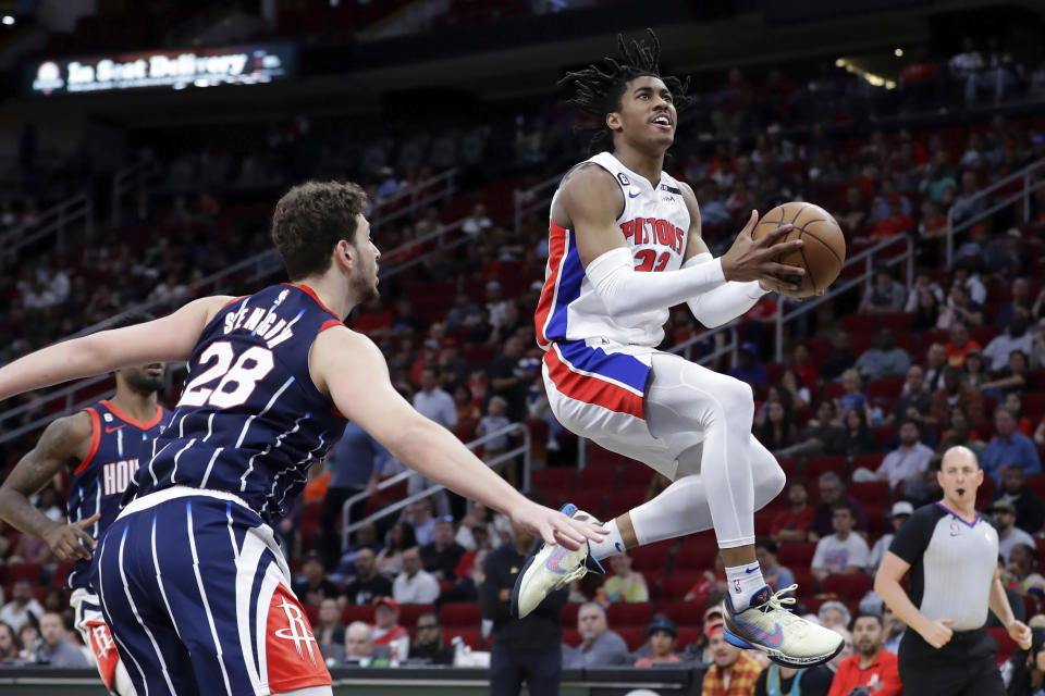 Detroit Pistons guard Jaden Ivey lays up a shot in front of Houston Rockets center Alperen Sengun, front left, during the first half of an NBA basketball game Friday, March 31, 2023, in Houston. (AP Photo/Michael Wyke)