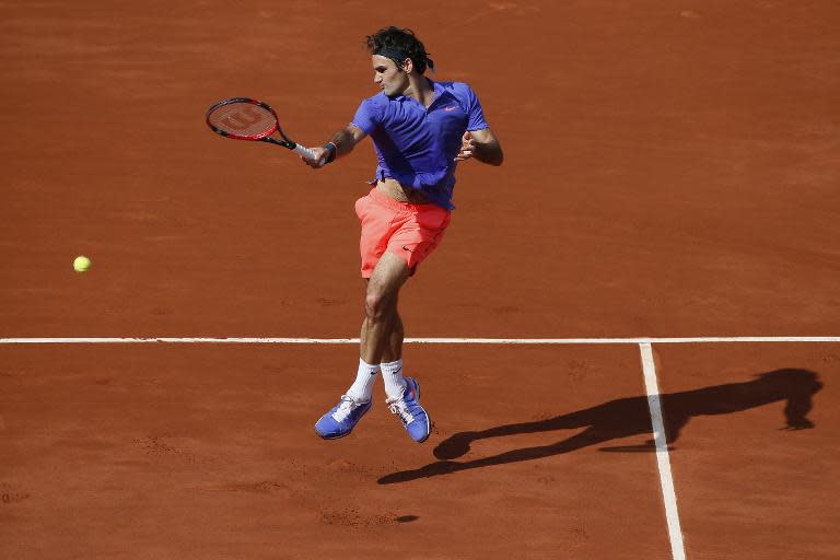 Switzerland's Roger Federer hits a return to Switzerland's Stanislas Wawrinka during their men's quarter final match of the Roland Garros 2015 French Tennis Open in Paris on June 2, 2015