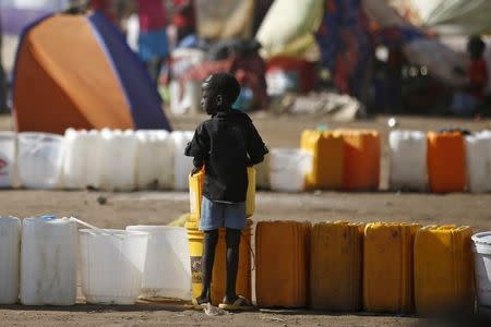 An internally displaced boy waits for water inside a United Nations Missions in Sudan (UNMIS) compound in Juba December 19, 2013. REUTERS/Goran Tomasevic