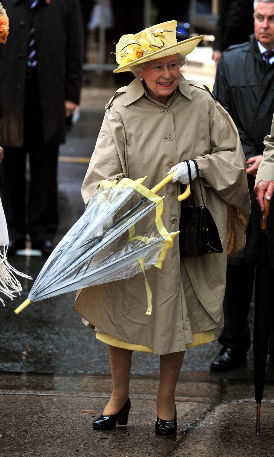 <p>Mit pastellgelben Akzenten kam Ihre Majestät 2010 im kanadischen Halifax an. Diese zeigten sich am Hut, unter dem Poncho und natürlich am Regenschirm. (Bild: Getty Images) </p>