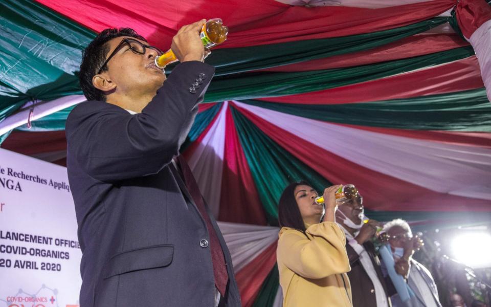 Madagascar's President Andry Rajoelina drinks a sample of the 'Covid Organics' at a launch ceremony in Antananarivo on April 20, 2020. - Rijasolo /AFP