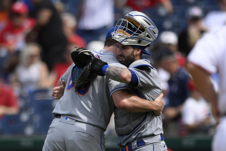 New York Mets relief pitcher Trevor May, left, and catcher Tomas Nido, right, hug after the first baseball game of a doubleheader against the Washington Nationals, Saturday, June 19, 2021, in Washington. The Mets won 5-1. (AP Photo/Nick Wass)