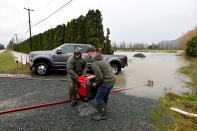 <p>Darryl Jansen and Jared Emery pump water away from a building after rainstorms lashed the western Canadian province of British Columbia, triggering landslides and floods, shutting highways, in Chilliwack, British Columbia, Canada November 15, 2021. REUTERS/Jennifer Gauthier</p> 