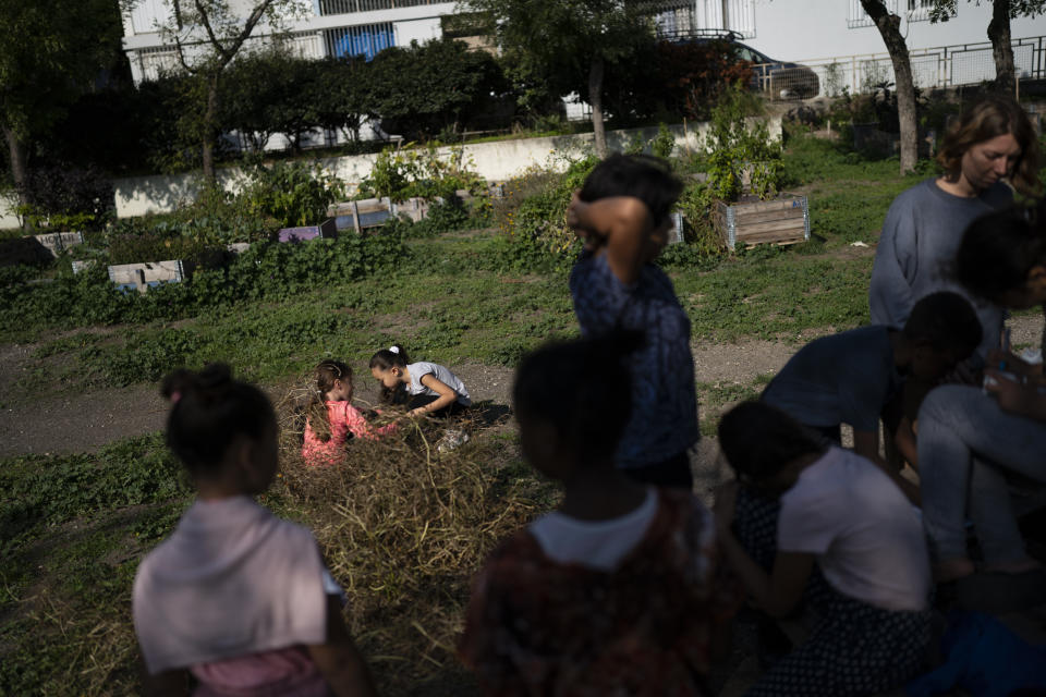 Children participate in gardening activities at the Cite de Frais Vallon in Marseille, southern France, Wednesday, Oct. 27, 2021. Urban gardens are sprouting hope in drug- and violence-plagued neighborhoods of Marseille. From publicly funded city-wide initiatives to residents taking it upon themselves to start cultivating the land around them, urban farming is changing the landscape and creating a space for community. (AP Photo/Daniel Cole)