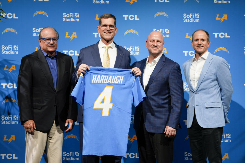 Jim Harbaugh, second from left, poses for photos with team owner Dean Spanos, left, and President of Business Operations John Spanos, right, during a press conference introducing him as the new head coach of the Los Angeles Chargers NFL football team, Thursday, Feb. 1, 2024, in Inglewood, Calif. (AP Photo/Ashley Landis)