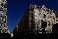 A person walks with buildings on the background in Lisbon