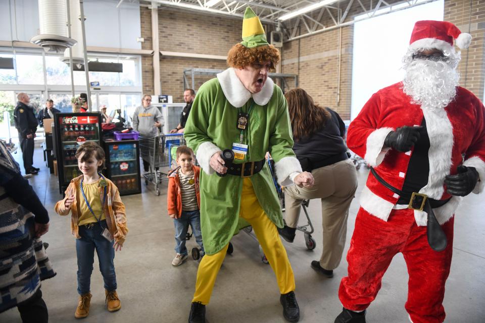 Buddy the Elf and Santa Claus dance in the checkout line during the Columbia County Sheriff's Office Day with a Deputy at Walmart on Thursday, Dec. 21, 2023.