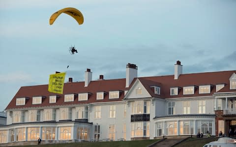 A Greenpeace protester flying a microlight passes over Donald Trump's resort in Turnberry with a banner reading "Trump: Well Below Par" - Credit: John Linton/PA