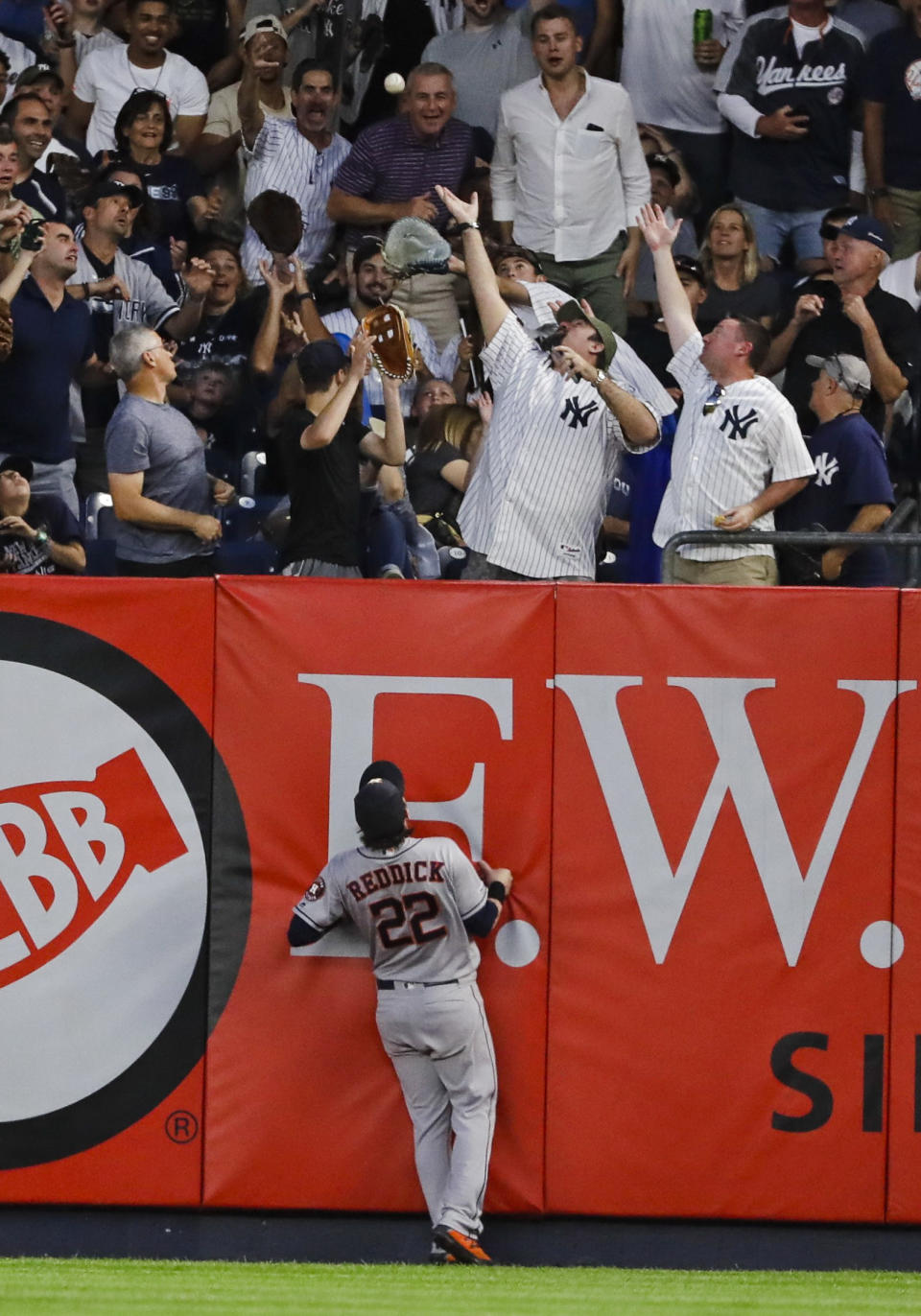 Houston Astros right fielder Josh Reddick (22) watches as fans reach for a two-run home run by New York Yankees' Gio Urshela during the fifth inning of a baseball game Saturday, June 22, 2019, in New York. (AP Photo/Frank Franklin II)