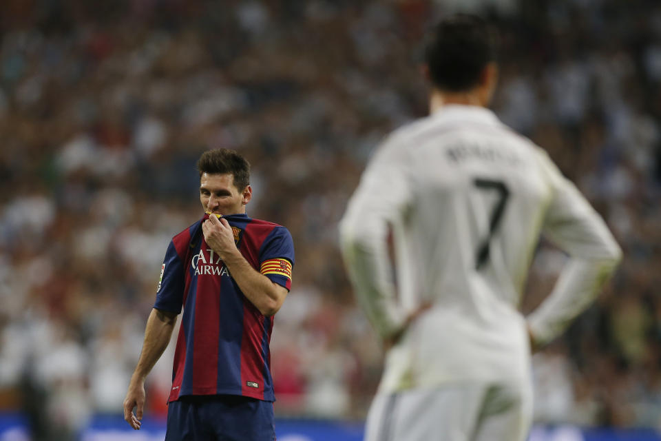 Barcelona's Lionel Messi, left, gestures next to Real Madrid's Cristiano Ronaldo, right,  during a Spanish La Liga soccer match between Real Madrid and FC Barcelona at the Santiago Bernabeu stadium in Madrid, Spain, Saturday, Oct. 25, 2014. (AP Photo/Andres Kudacki)