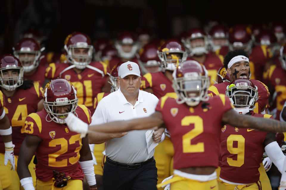 Southern California coach Clay Helton, center, runs onto the field with his team for an NCAA college football game against Utah on Friday, Sept. 20, 2019, in Los Angeles. (AP Photo/Marcio Jose Sanchez)