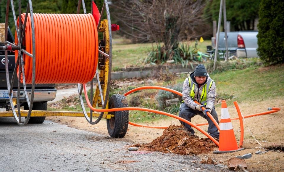 Alberto Lopez feeds fiber cable along Glenwood Avenue on Monday, Dec. 5, 2022.