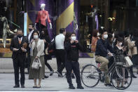 People wearing protective masks to help curb the spread of the coronavirus wait to walk across a pedestrian crossing in Tokyo, Wednesday, Oct. 28, 2020. The Japanese capital confirmed more than 170 new coronavirus cases on Wednesday. (AP Photo/Eugene Hoshiko)