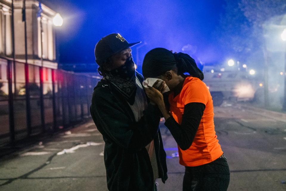 A man helping a woman during a street protest in Kenosha, Wisconsin.