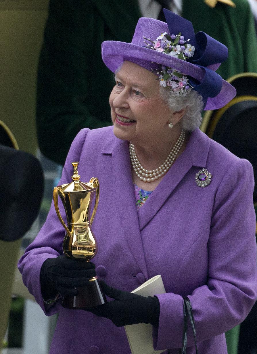 Britain's Queen Elizabeth II with a trophy after her horse Estimate won the Gold Cup, during day three of the Royal Ascot meeting, at Ascot Racecourse, in Ascot, England, England, Thursday, June 20, 2013. (AP Photo/Alastair Grant)