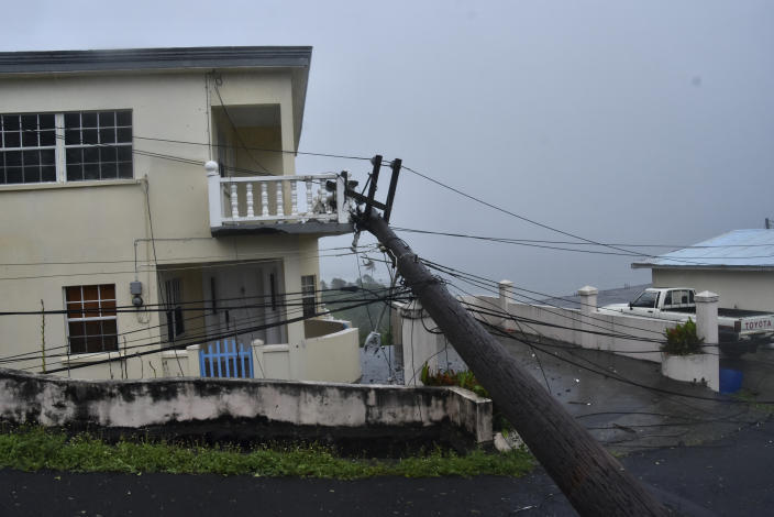 An electrical pole felled by Hurricane Elsa leans on the edge of a residential balcony, in Cedars, St. Vincent, Friday, July 2, 2021. Elsa strengthened into the first hurricane of the Atlantic season on Friday as it blew off roofs and snapped trees in the eastern Caribbean, where officials closed schools, businesses and airports. (AP Photo/Orvil Samuel)