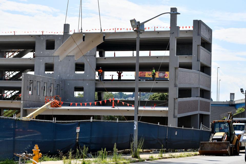 A large crane lowers a section of a parking garage under construction at the site of the former Our Lady of Mount Carmel Church Tuesday.