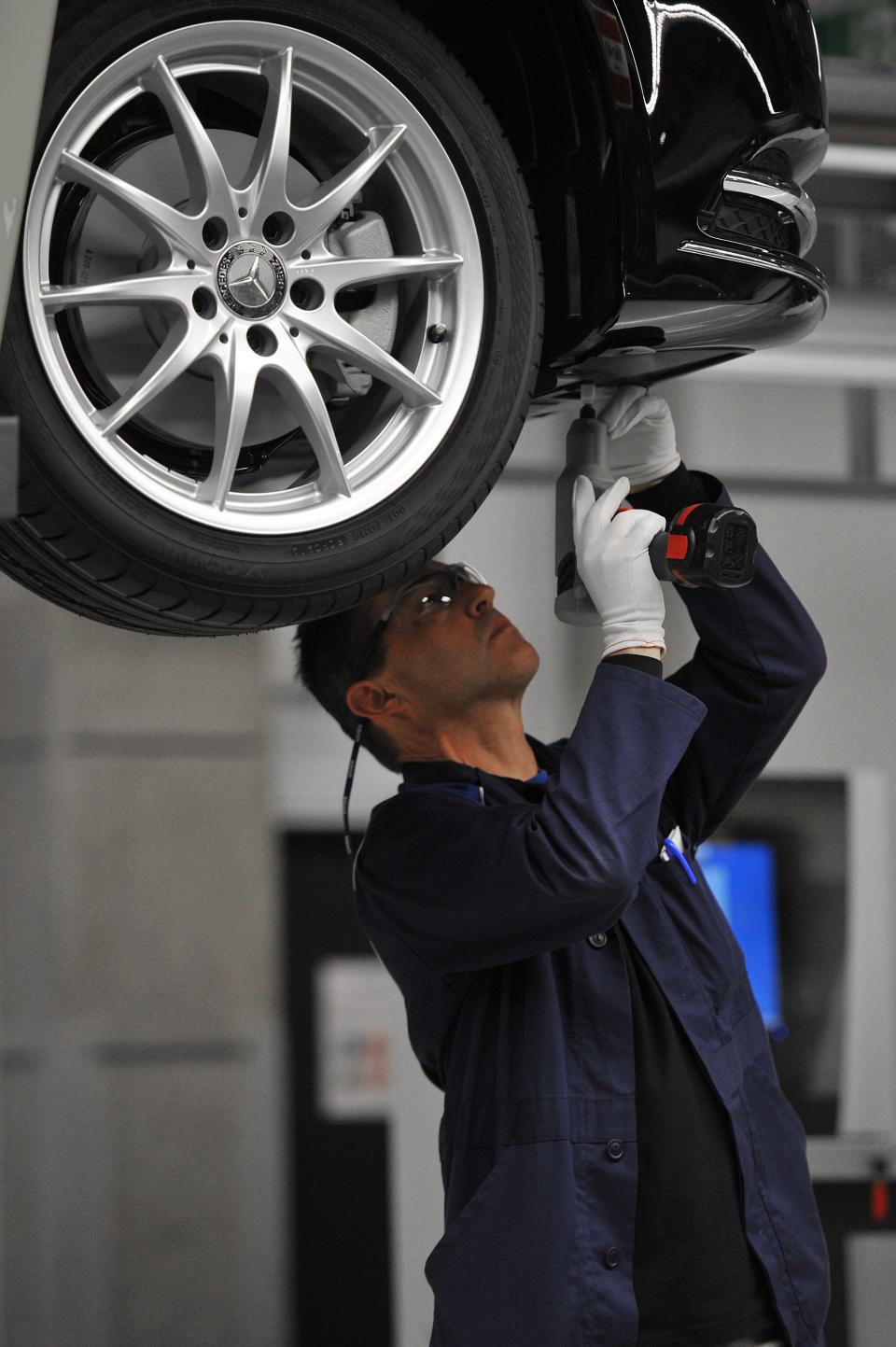 An employee works on a car in the assembly hall in the new Mercedes Benz plant in Kecskemet, 83 kilometers southeast of Budapest, Hungary, prior to the the official inauguration ceremony of the Kecskemet Mercedes factory on Thursday, 29 March, 2012. The new Mercedes plant built on a basic territory of 441 hectares with an investment of 800 million euros has a yearly capacity of 100,000 cars of two types of compact B-Class produced by 2,500 employees. (AP Photo/MTI, Tamas Kovacs)