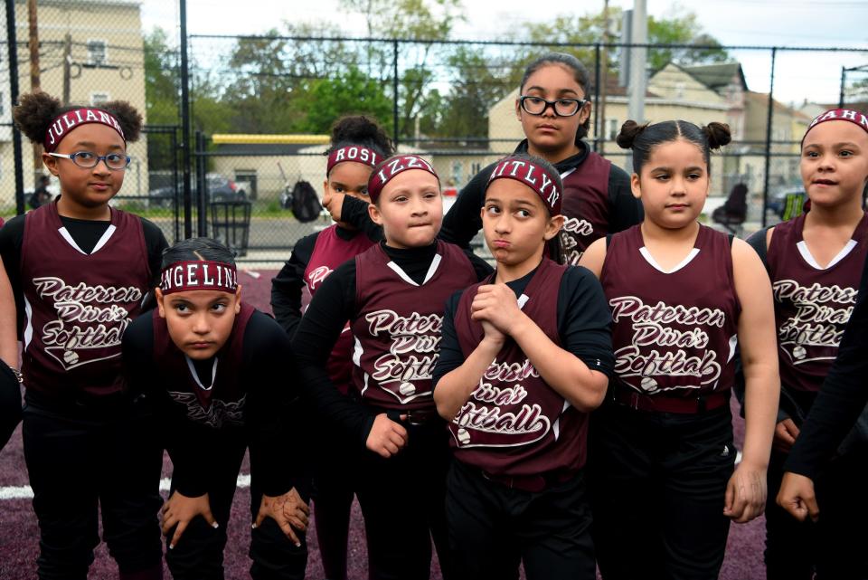 The Paterson Divas, 10 and under softball team is raising funds to play in a July tournament in Puerto Rico. The team listen gathers for a meeting after practice at Brandes Field in Paterson on May 10, 2022.