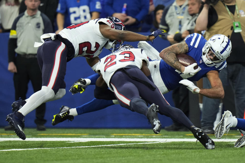 Indianapolis Colts wide receiver Michael Pittman Jr. (11) is tackled by Houston Texans safety M.J. Stewart and safety Eric Murray (23) during the second half of an NFL football game between the Houston Texans and Indianapolis Colts, Sunday, Jan. 8, 2023, in Indianapolis. (AP Photo/AJ Mast)