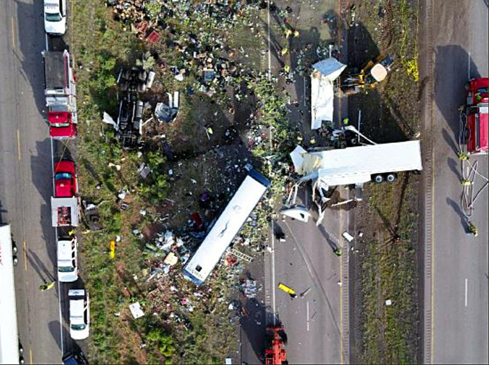 This Friday, Aug. 31, 2018 photo from the New Mexico State Police shows the scene of a collision Thursday between a Greyhound passenger bus and a semitrailer on Interstate 40 near the town of Thoreau, N.M., near the Arizona border. A California-based trucking company and one of its drivers were accused of negligence Friday in a pair of lawsuits as investigators sorted through the wreckage from the deadly bus crash on a New Mexico highway. (New Mexico State Police via AP)