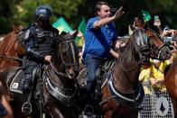 Brazil's President Jair Bolsonaro rides a horse during a meeting with supporters protesting in his favor, amid the coronavirus disease (COVID-19) outbreak, in Brasilia