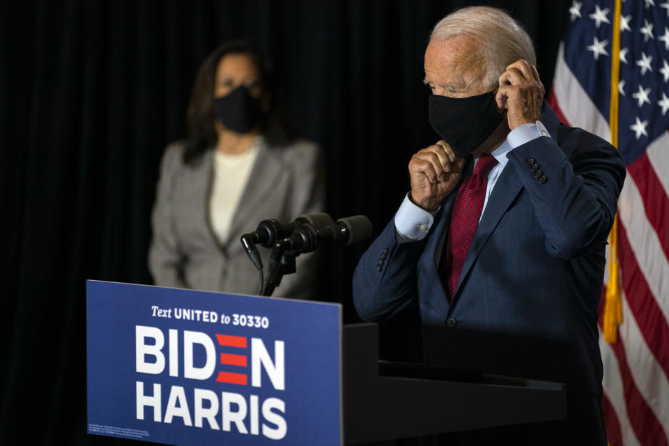 Democratic presidential candidate former Vice President Joe Biden joined by his running mate Sen. Kamala Harris, D-Calif., replaces his face mask after speaking at the Hotel DuPont in Wilmington, Del., Thursday, Aug. 13, 2020. (AP Photo/Carolyn Kaster)