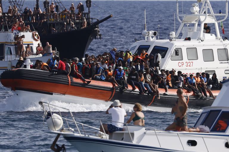 18 de septiembre de 2023, Italia, Lampedusa: Migrantes rescatados llegan en una embarcación al puerto de Lampedusa entre dos barcos de turistas. Un gran número de migrantes procedentes de África han llegado esta semana a la isla del mar Mediterráneo. Foto: Cecilia Fabiano/LaPresse vía ZUMA Press/dpa