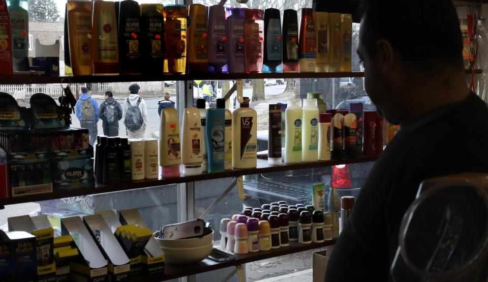 Corner market owner Junior Hernandez watches as students walk past his store in Lawrence, Mass., Wednesday, Dec. 5, 2018. Hernandez said he has lost most of his customers and can't offer the usual hot and perishable foods to residents in his neighborhood, because they have been relocated for months since a gas line failure on Sept. 13, 2018. Residents and business owners are dealing with the after effects of the crisis. (AP Photo/Charles Krupa)