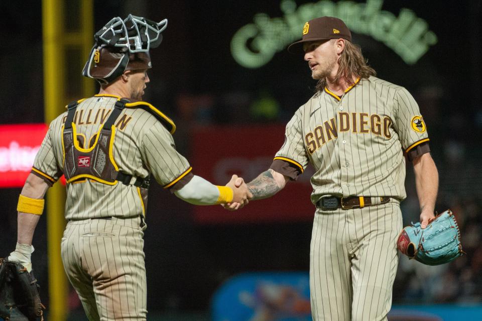 San Diego Padres catcher Brett Sullivan (29) and relief pitcher Josh Hader (71) shake hands after defeating the San Francisco Giants at Oracle Park.