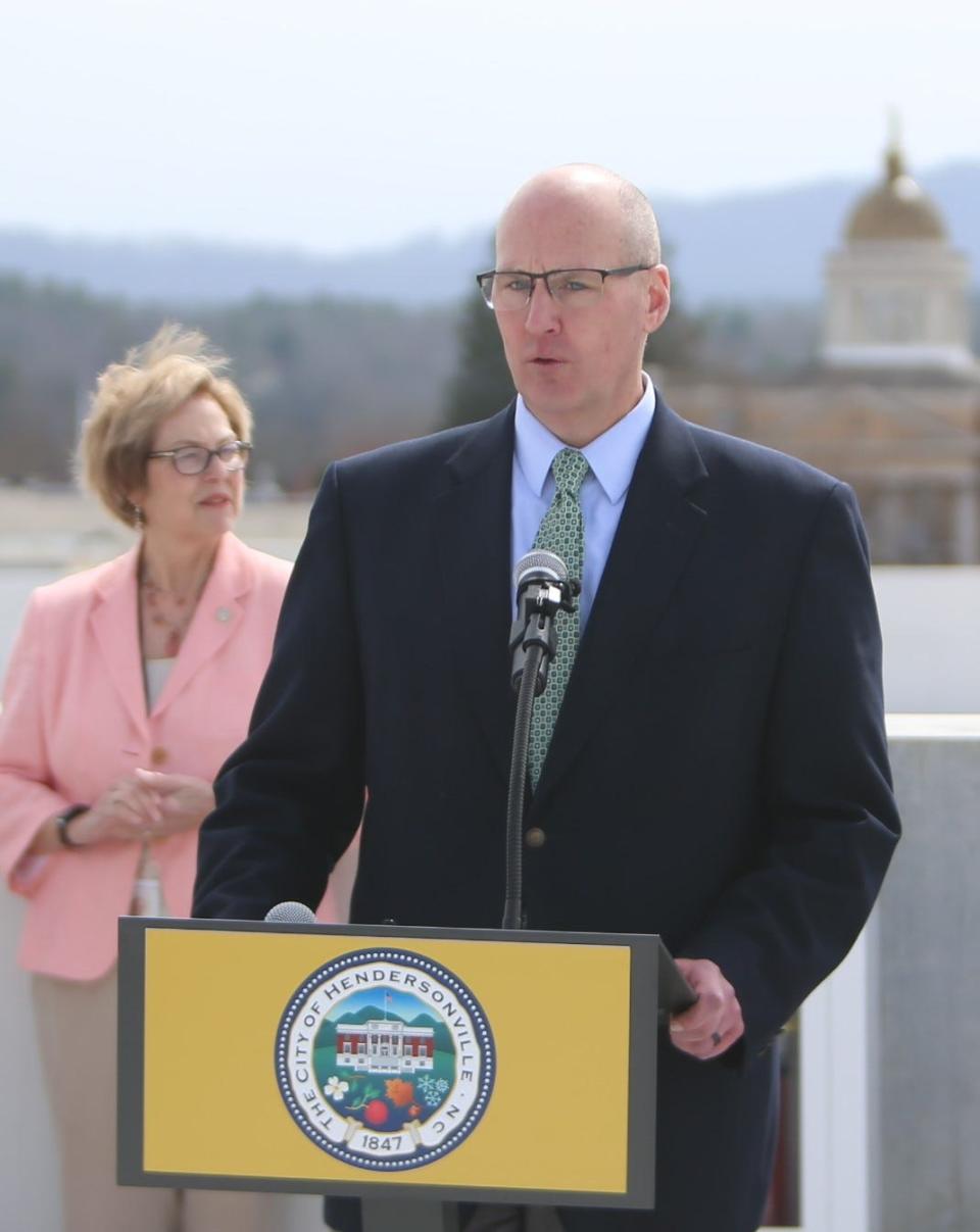 Hendersonville City Manager John Connet makes opening remarks at the March 1 grand opening of the city's new parking deck as Mayor Barbara Volk looks on.