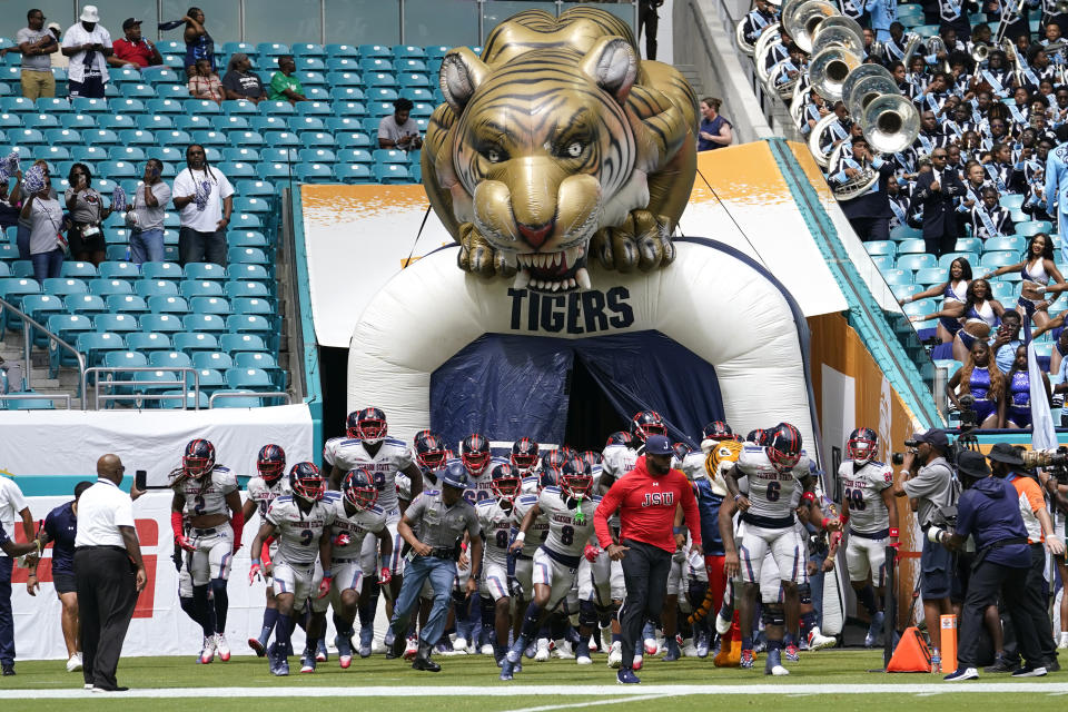 Jackson State head coach T.C. Taylor, center, leads his team onto the field before the Orange Blossom Classic NCAA college football game against Florida A&M, Sunday, Sept. 3, 2023, in Miami Gardens, Fla. (AP Photo/Lynne Sladky)