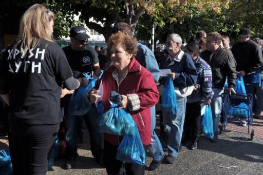 People queue for a free food distributed by members of Greece's ultra nationalist party Golden Dawn, in Athens. EU finance ministers are tackling ways of boosting the slumping economy as the debt crisis bites deeper, after eurozone ministers reported progress overnight on the Greek bailout