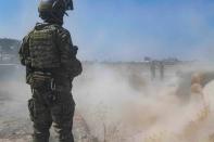 In this Sept. 21, 2019, photo, released by the U.S. Army, a U.S. soldier oversees members of the Syrian Democratic Forces as they demolish a Kurdish fighters' fortification as part of the so-called "safe zone" near the Turkish border. (U.S. Army photo by Staff Sgt. Andrew Goedl via AP)