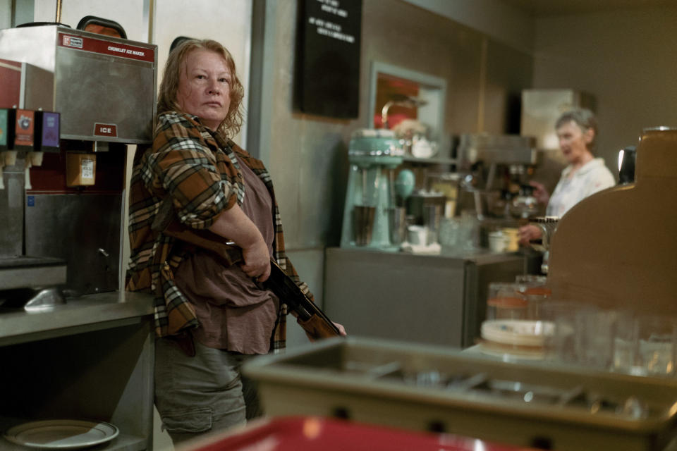 Elizabeth Saunders wields a shotgun behind the counter of a diner