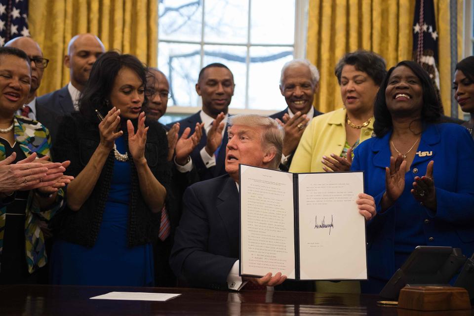 President Donald Trump holds up an executive order to bolster historically black colleges and universities (HBCUs) after signing it in the Oval Office of the White House in Washington, D.C., on Feb. 28, 2017.