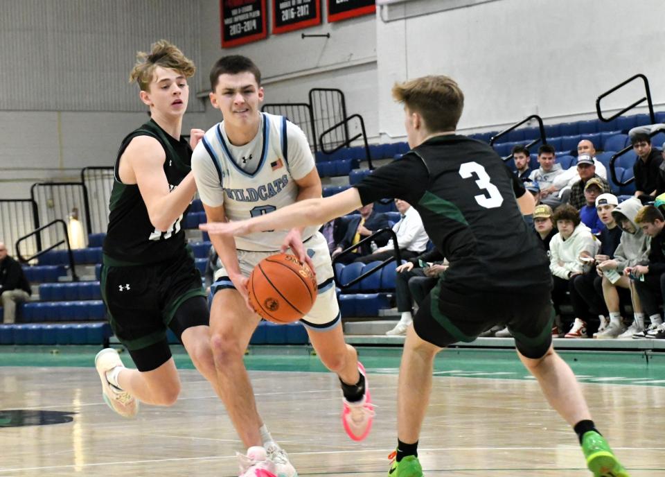 York’s Connor Roberge, center, tries to split the Spruce Mountain defense of Owen Kelvey and Caden Frazier (3) in Friday's Class B South quarterfinal at the Portland Expo. No. 3 York advanced to Tuesday's semifinal round with a 50-37 win. The Wildcats will face No. 2 Lincoln Academy at the Expo.