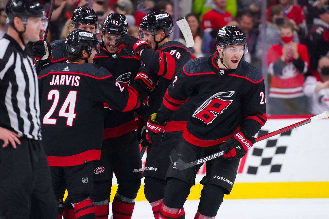 Carolina Hurricanes defenseman Brett Pesce (22) celebrates a goal with Seth Jarvis (24), Martin Necas (88), Jesperi Kotkaniemi (82) and Jordan Staal (11) against the Arizona Coyotes at PNC Arena in October 2021.