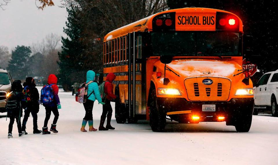 Mark Twain Elementary students board their school bus after standing in Monday morning’s snow and freezing rain at the bus stop on the corner of Road 36 and West Riverhaven Street in Pasco. It was back to school for many students and teachers at Tri-City area schools following winter break.