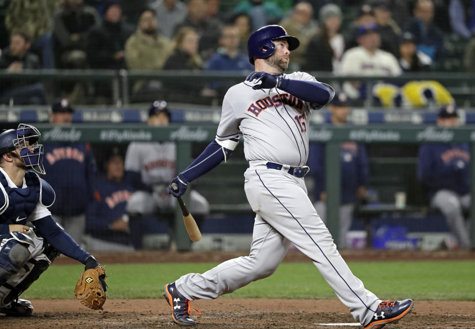 FILE - In this April 17, 2018, file photo, Houston Astros' Brian McCann, right, and Seattle Mariners catcher Mike Marjama watch the path of McCann's two-run home run in the sixth inning of a baseball game in Seattle. A person familiar with the negotiations tells The Associated Press that McCann has agreed to return to the Atlanta Braves for a $2 million, one-year contract. The person spoke on condition of anonymity Monday, Nov. 26, 2018, because the agreement had not yet been announced. (AP Photo/Elaine Thompson, File)