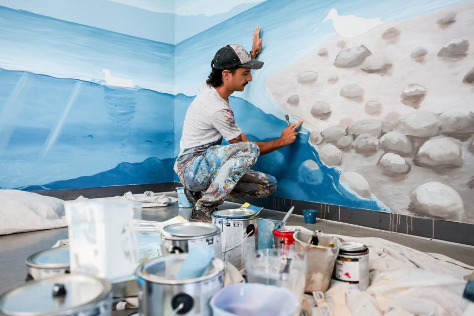 Argentinian artist Franco Cervata Cozza, who also goes by the artist name Vato, paints a mural at the George S. and Dolores Doré Eccles Wildlife Education Center in Farmington on Saturday.